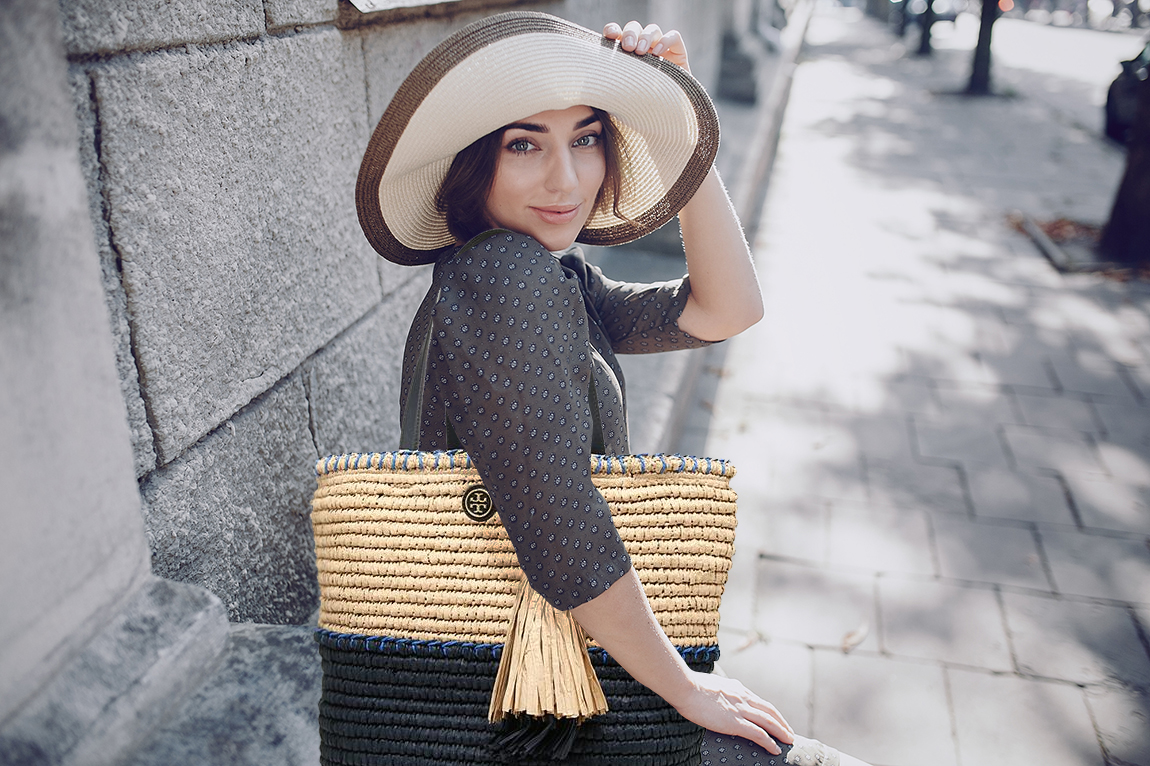 beautiful young model standing in a hat outdoors